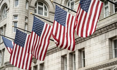 a group of american flags hanging from a street light