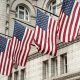 a group of american flags hanging from a street light